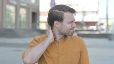 Casual Young Man having Neck Pain Outdoor