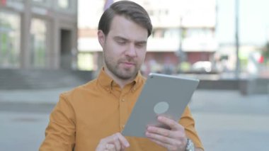 Upset Casual Young Man Reacting to Loss on Tablet Outdoor