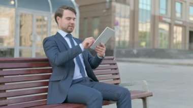 Young Businessman Celebrating Online Win on Tablet Outdoor