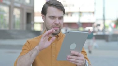 Video Call on Tablet by Casual Young Man Outdoor