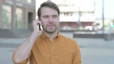 Casual Young Man Talking on Phone Outdoor