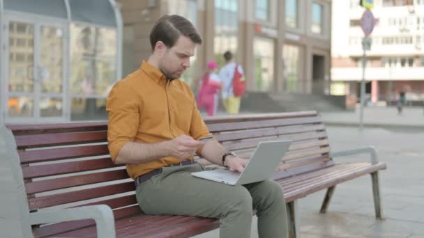 Excited Casual Young Man Shopping Online Sitting Outdoor — Stockvideo