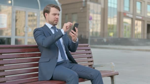 Young Businessman Browsing Internet Smartphone While Sitting Outdoor Bench — Stockvideo