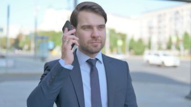 Portrait of Middle Aged Businessman Talking on Phone Outdoor