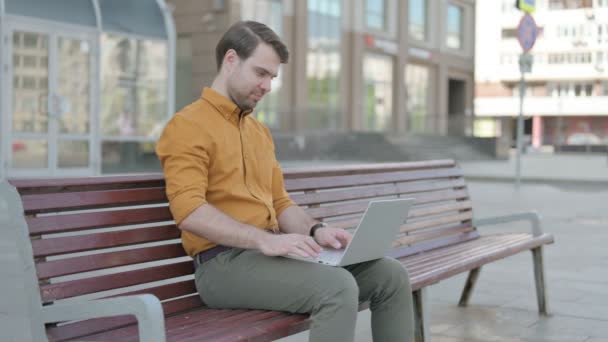 Casual Young Man Celebrating Success Laptop While Sitting Outdoor Bench — Stockvideo