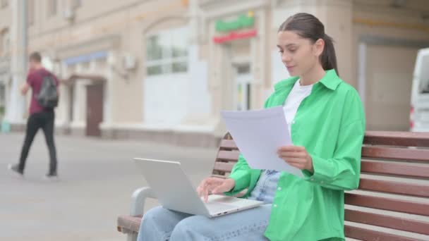 Young Woman Reading Documents Using Laptop While Sitting Outdoor — ストック動画