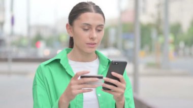 Excited Young Woman Shopping Online on Smartphone Outdoor