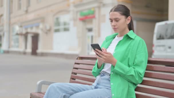 Young Woman Reacting Loss Smartphone While Sitting Outdoor Bench — Vídeos de Stock