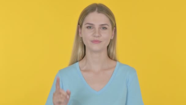 Casual Young Woman Inviting Yellow Background — Stockvideo