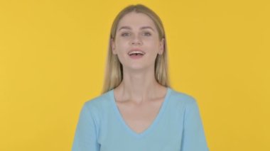 Casual Young Woman Shaking Head in Approval on Yellow Background 