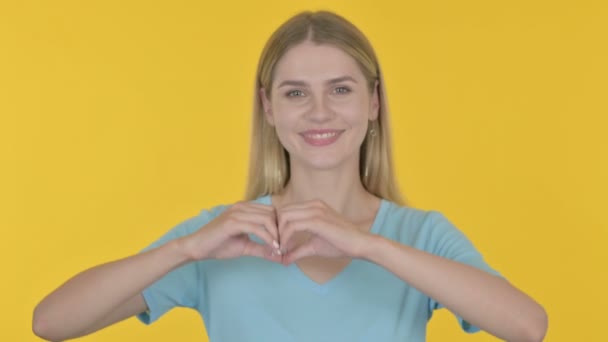 Casual Young Woman Showing Heart Shape Hands Yellow Background — Stockvideo