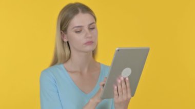 Casual Young Woman Reacting to Loss on Tablet on Yellow Background 