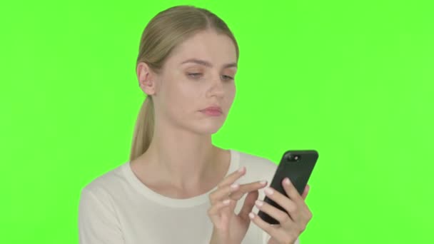 Casual Young Woman Loss Smartphone Green Background — Stockvideo