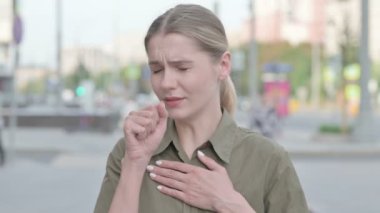 Unwell Young Woman Coughing while Standing Outdoor
