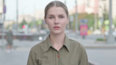 Portrait of Young Woman Looking at the Camera Outdoor