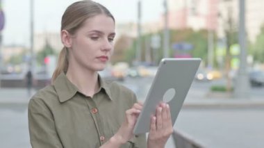 Upset Young Woman Reacting to Loss on Tablet Outdoor