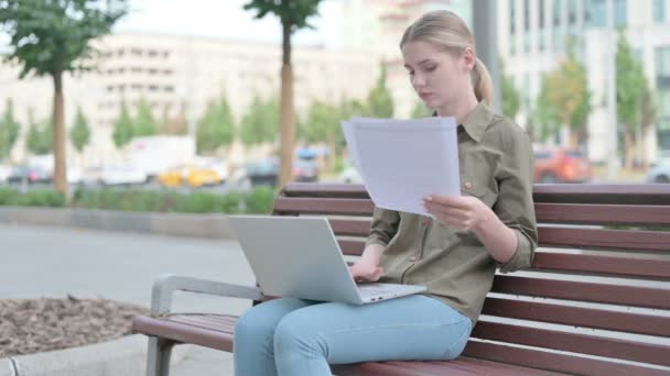 Young Woman Reading Documents Working Laptop While Sitting Bench Outdoor — Stok video