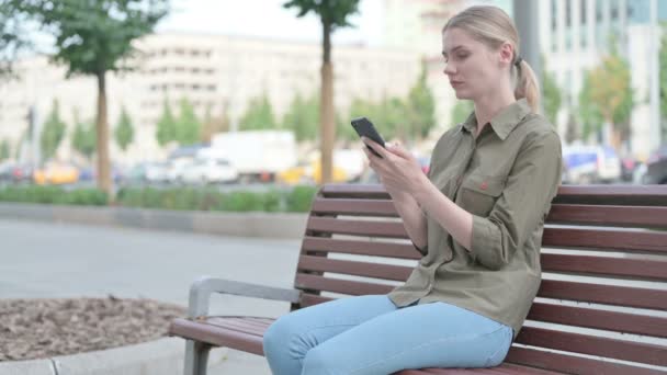 Young Woman Reacting Loss Smartphone While Sitting Outdoor Bench — 图库视频影像