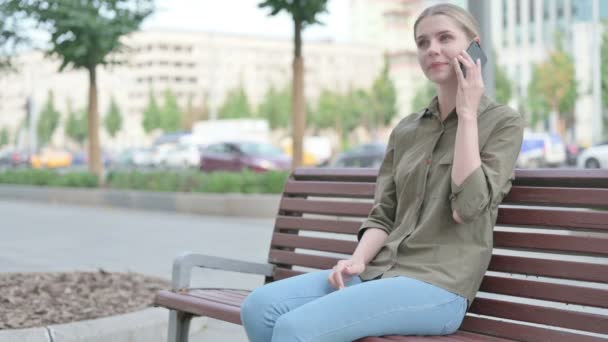Молодая Женщина Разговаривает Телефону Сидя Скамейке — стоковое видео