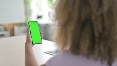 Yeşil ekranlı akıllı telefon kullanan Afrikalı Amerikalı kadın. 