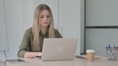 Blonde Young Woman dizüstü bilgisayarla uğraşırken baş ağrısı çekiyor