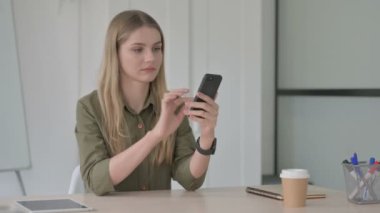 Ofiste Akıllı Telefon kullanan Sarışın Genç Kadın 