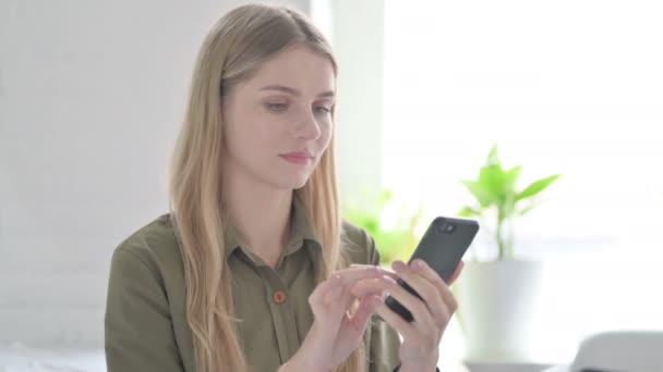 金发女青年在智能手机上庆祝网上成功 — 图库视频影像