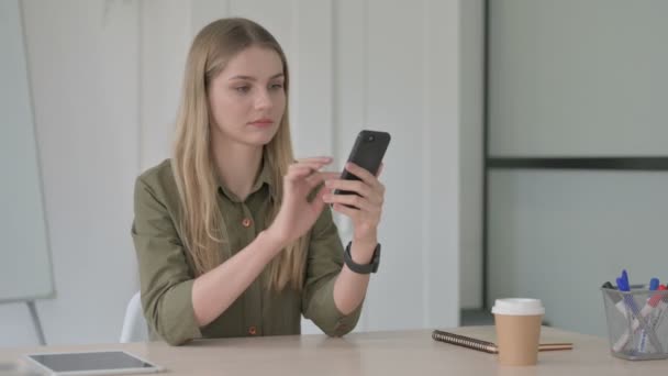 在办公室使用智能手机的金发女青年 — 图库视频影像