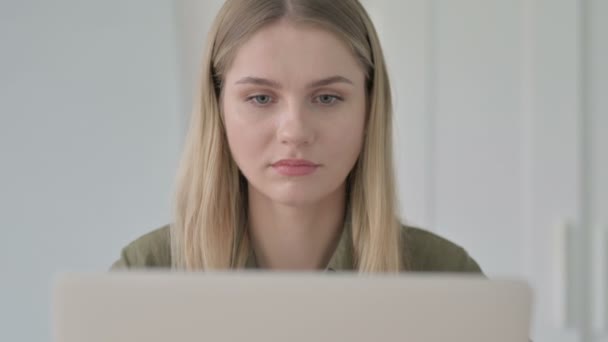 布朗德年轻女子使用笔记本电脑时在相机前微笑的特写 — 图库视频影像