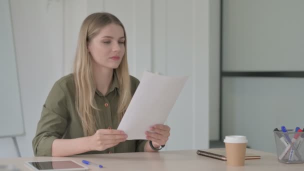 Blondine Jonge Vrouw Vieren Winnen Tijdens Het Lezen Van Documenten — Stockvideo