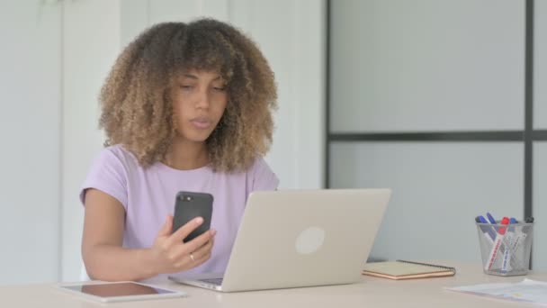 Africká Americká Žena Procházení Internetu Smartphone Při Použití Notebooku Kanceláři — Stock video