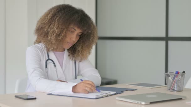 アフリカ女性医師クリニックでの医療報告書とノートパソコンの作業 — ストック動画