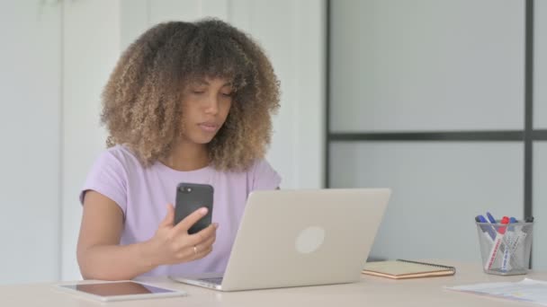 Mujer Afroamericana Hablando Por Teléfono Mientras Usa Ordenador Portátil Oficina — Vídeos de Stock