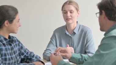 Takım arkadaşlarıyla toplantı sırasında konuşan genç kadın.