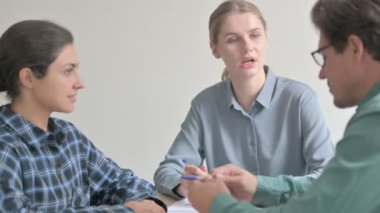 Genç kadın takım arkadaşlarıyla iş konuşuyor.