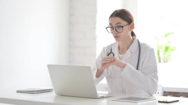 Genç Kadın Doktor Ofisteki Dizüstü bilgisayardan Konuşuyor