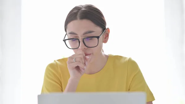 Portrait of Young Woman Coughing while using Laptop