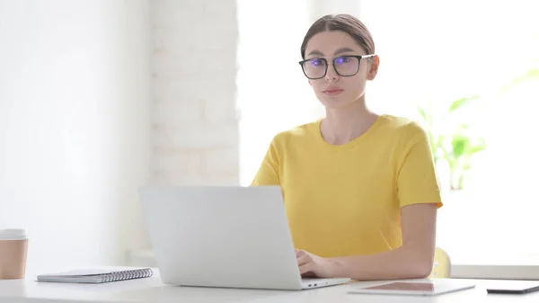Junge Frau Blickt Büro Mit Laptop Auf Kamera — Stockfoto