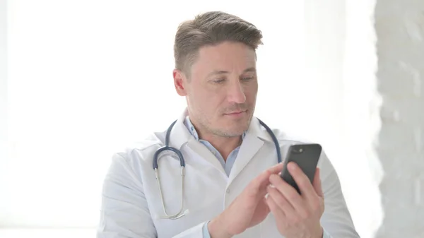 スマートフォンを用いた中年医師の肖像 — ストック写真