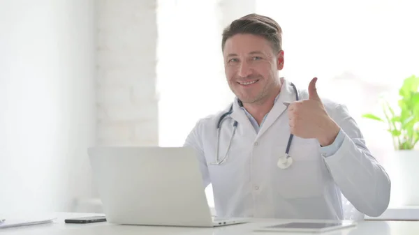 Middle Aged Doctor Showing Thumbs Sign While Using Laptop Office — Foto de Stock