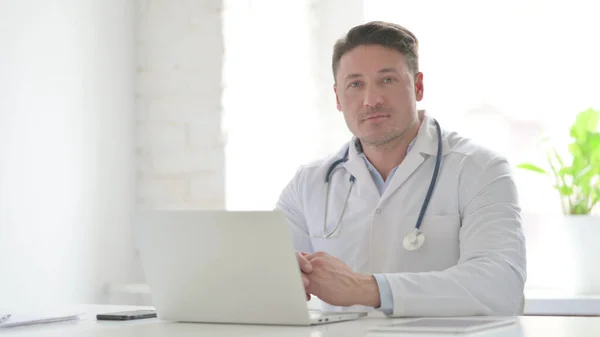 Middle Aged Doctor Looking Camera While Using Laptop Office — Foto de Stock