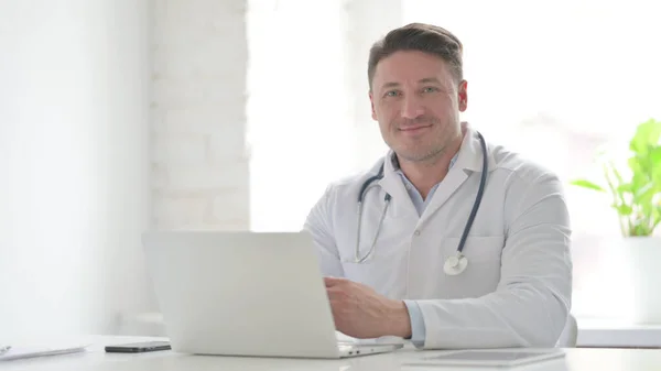 Middle Aged Doctor Smiling Camera While Using Laptop Office — Foto de Stock