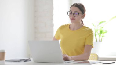 Ofiste dizüstü bilgisayar kullanırken Sırt Ağrısı Olan Genç Kadın