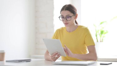 Ofiste otururken Tablet kullanan Genç Kadın