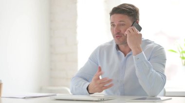 Ofiste Orta yaşlı adam konuşuyor.