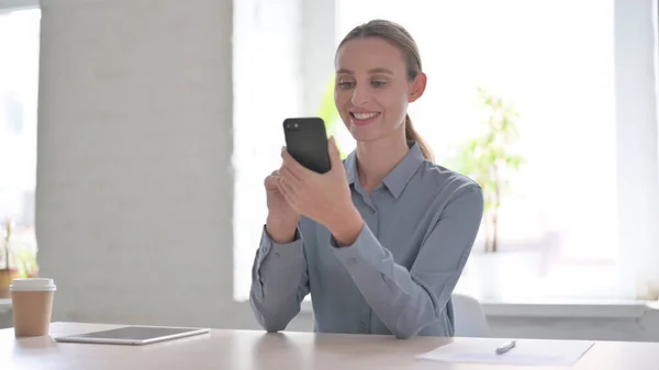 Ofiste Akıllı Telefon Kullanan Çekici Genç Kadın — Stok fotoğraf