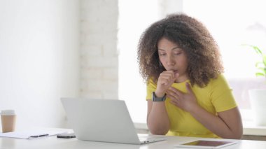 Ofiste dizüstü bilgisayar kullanırken öksüren genç Afrikalı Kadın