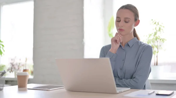 Mujer Joven Pensando Mientras Trabaja Ordenador Portátil Oficina —  Fotos de Stock