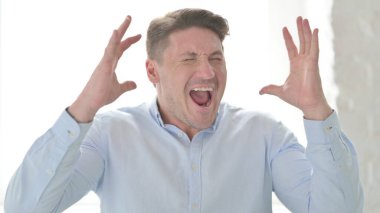 Orta yaşlı adam bağırıyor, çığlık atıyor.