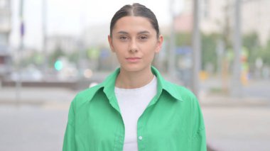 Portrait of Young Woman Looking at the Camera Outdoor